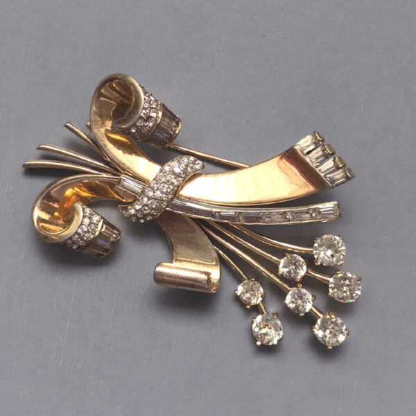 MAZER retro brooch with a ribbon design and a spray of clear rhinestones in gold plated sterling silver, 1940s
