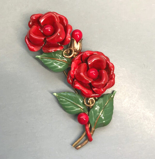 TRIFARI fur clip with red enameled flowers and green leaves in a gold tone setting,1941