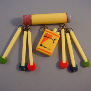 MOE by Jackie Weeks bakelite brooch, with a cigarette, matches and cigarette package with painted details