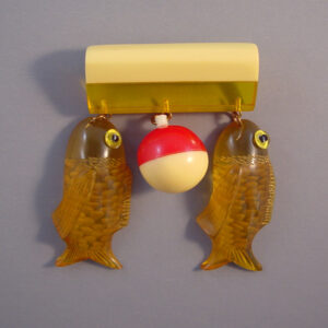 MOE by Jackie Weeks bakelite fish and bobber float bar brooch in apple juice, red and yellow, early 2000s