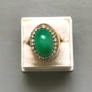 PANETTA green statement ring with a dome shaped translucent green glass oval center surrounded by a halo of brilliant clear rhinestones