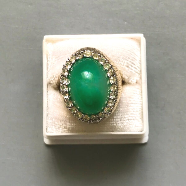 PANETTA green statement ring with a dome shaped translucent green glass oval center surrounded by a halo of brilliant clear rhinestones